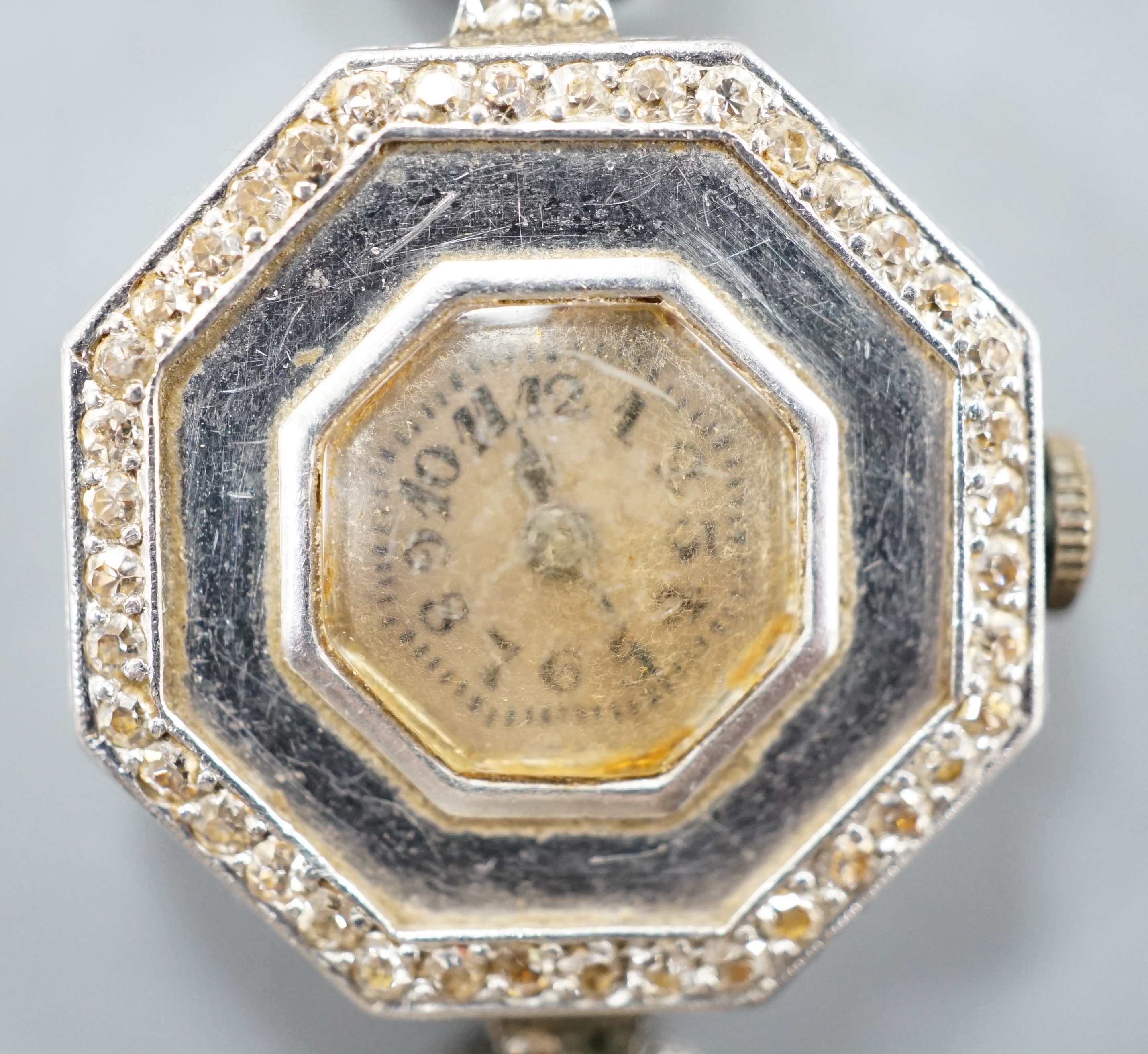 A lady's early 20th century white metal and diamond chip set manual wind octagonal cocktail watch, on a white metal twin strand mesh bracelet, gross 27.4 grams.